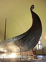 Un grand bateau viking exposé dans un musée de drakkars historiques.