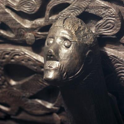Sculpture en bois du Vieux Norrois représentant un homme avec un serpent sur la tête - Exposition sur l’histoire des Vikings.