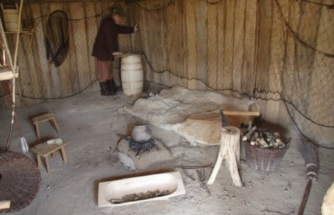 Un homme travaillant dans une petite pièce d’une maison viking.