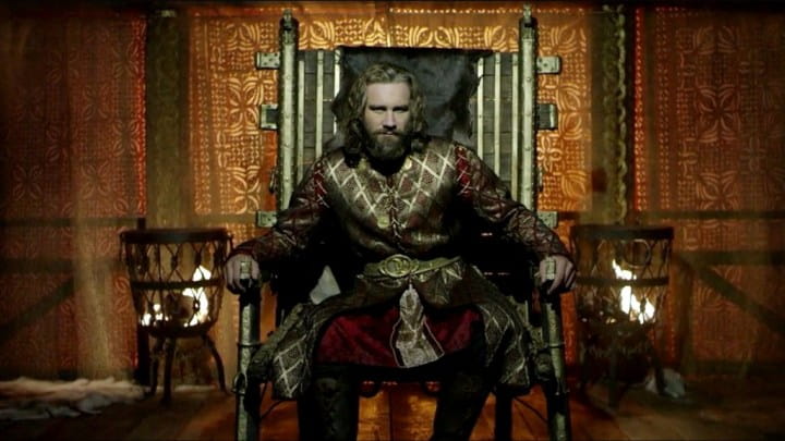 Gros plan d’un homme assis sur une chaise dans une pièce, lié à ’Qui était Rollo, duc viking de Neustrie ?’.